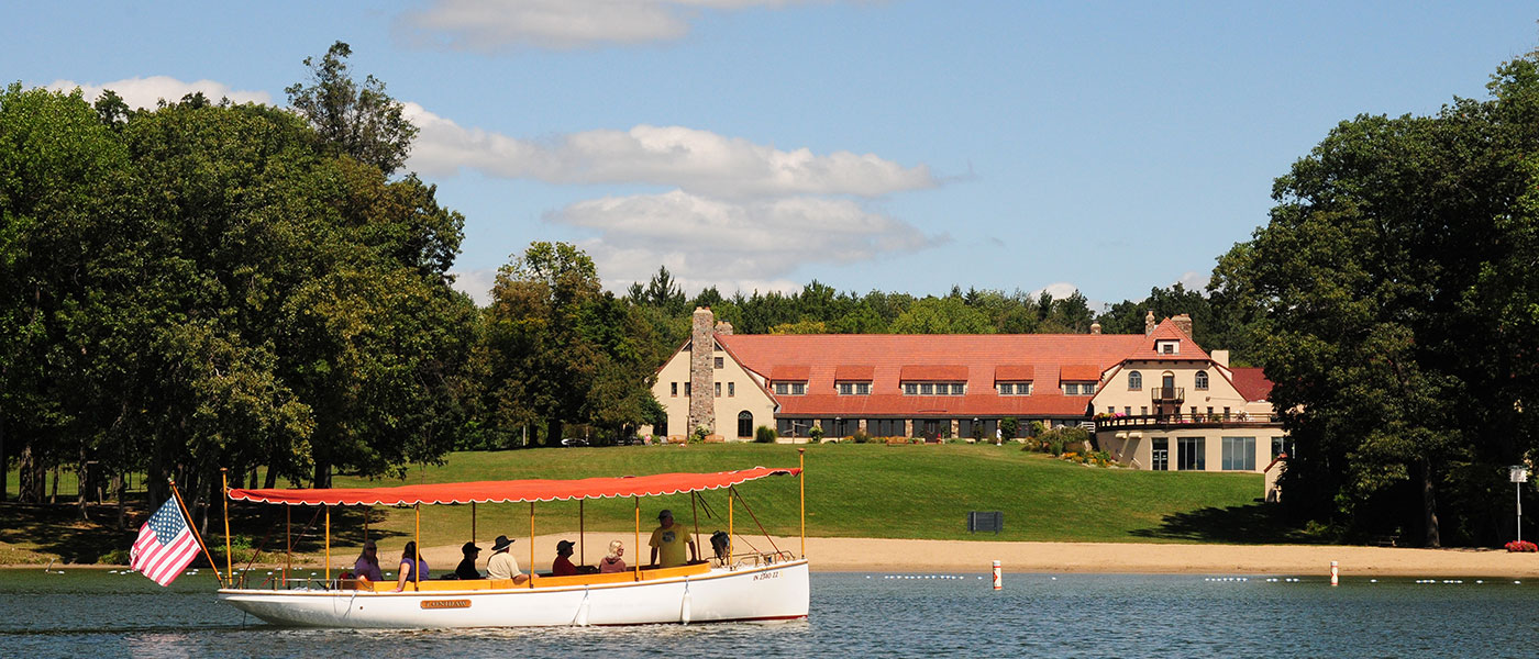 a boat approaching a house surrounded by trees
