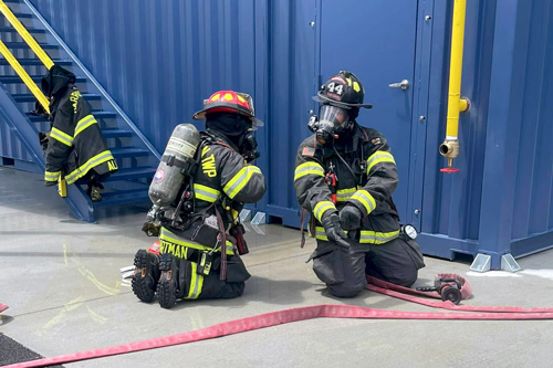 Firefighters kneel and talk during training at Corydon facility