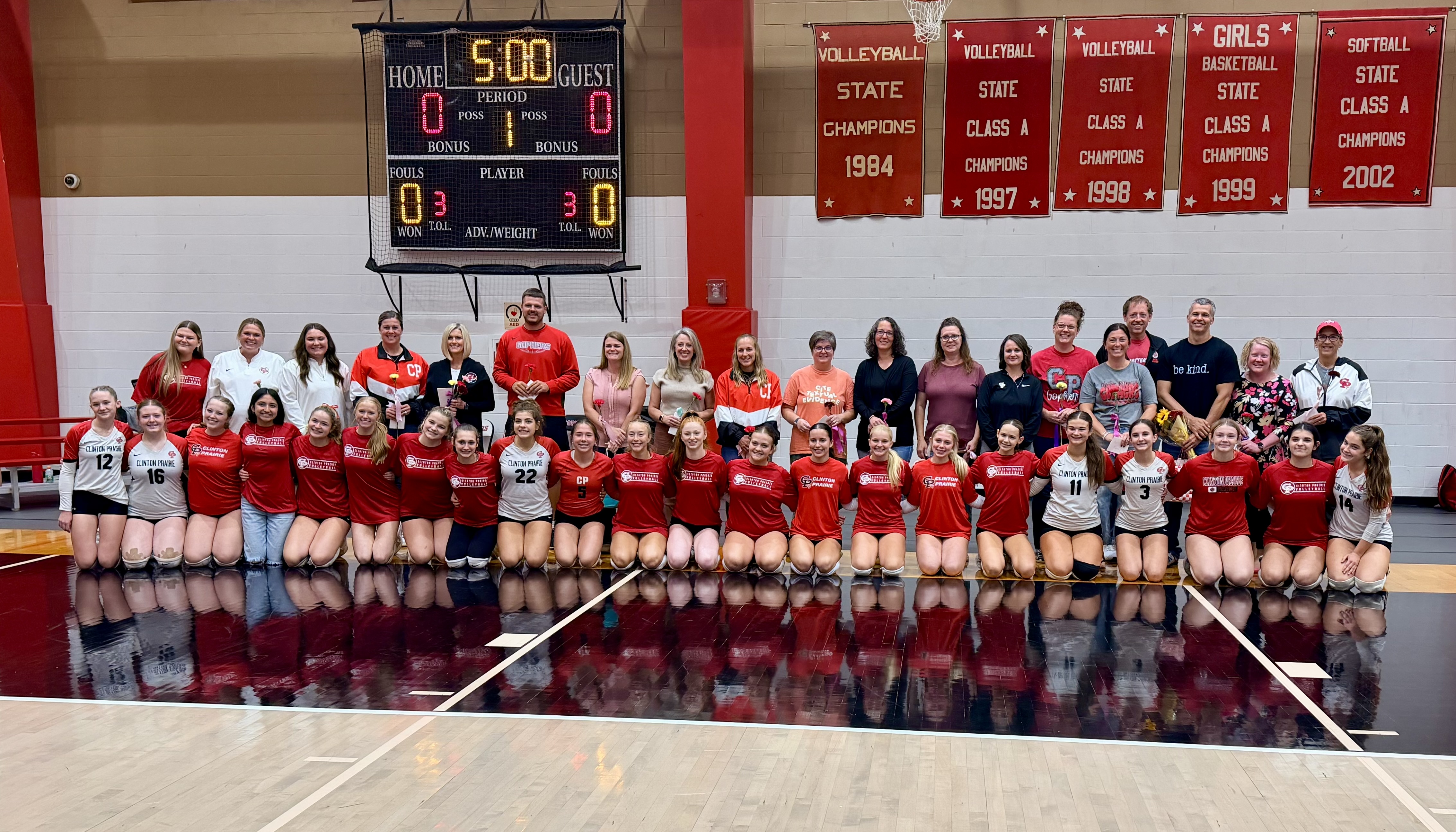 Junior High Volleyball and Teachers across both buildings share a photo during teacher appreciation night.