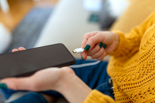 Person plugging phone into charger