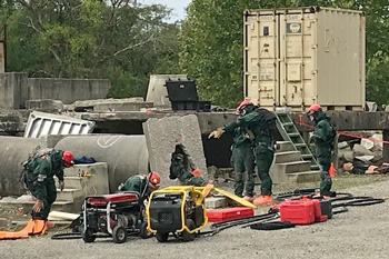 Rescuers searching through rubble during training
