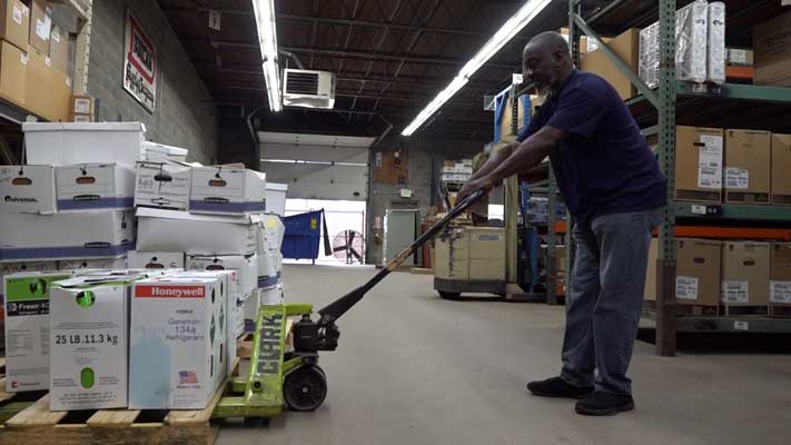 Featured speaker in video, Harold Johnson, performing work in the warehouse