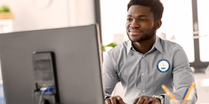 young male BMV employee facing a computer monitor