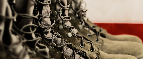 Close-up of military boot all in a row with part of the American flag in the background