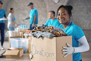 Volunteer holding box of donated clothing Volunteer holding box of donated clothing