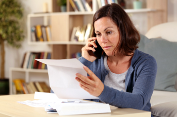 Person holding mail while on phone