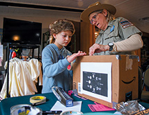 Spring Mill State Park seasonal interpretive naturalist Jill Lutes helps 8-year-old Natalie Henley build an eclipse viewer inside the park&rsquo;s Lakeview Activity Center.