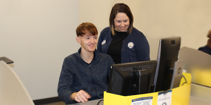 branch manager helping a new employee complete a transaction