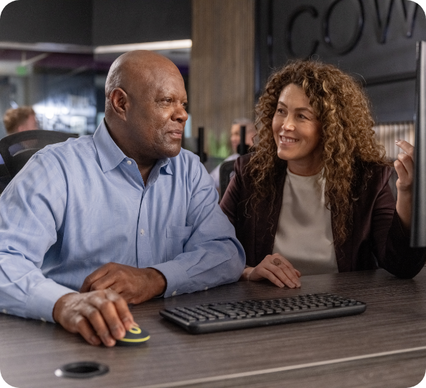 Older man smiling while working at a computer.