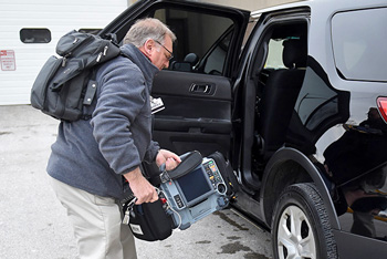 Community paramedic loading equipment into SUV