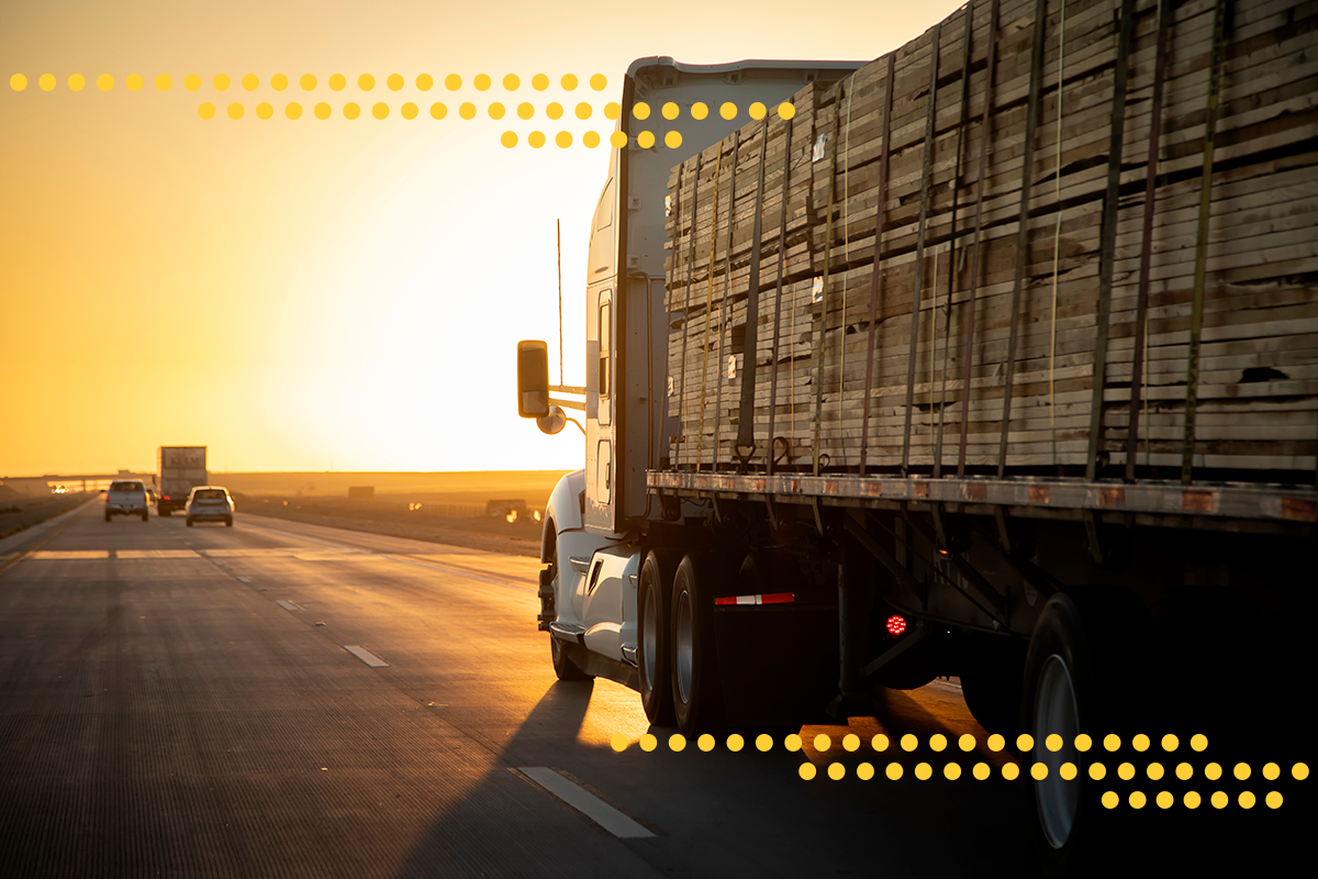 Semi truck on a freeway with the sunset in the background