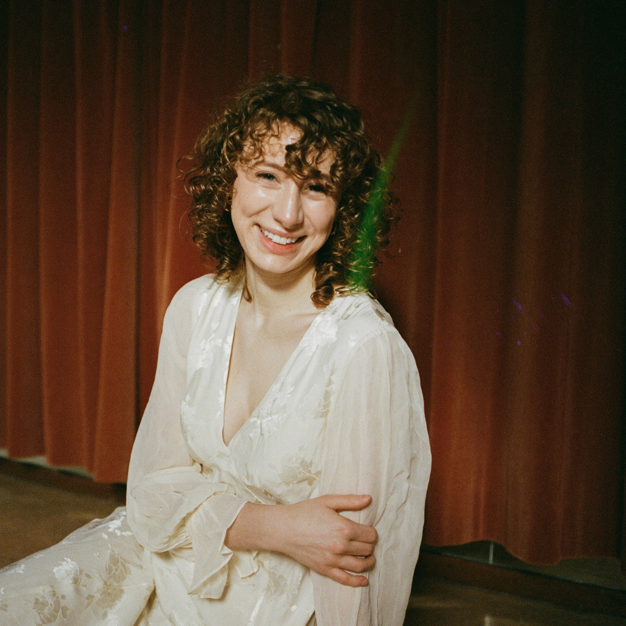 Woman in front of red curtain
