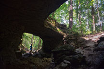 A hiker pauses beneath one of the Twin Bridges rock formations near Wolf Cave at McCormick's Creek State Park last August. McCormick&rsquo;s Creek became Indiana&rsquo;s first state park in 1916. (John Maxwell photo)