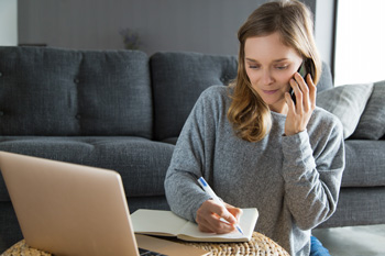 Woman on phone taking notes