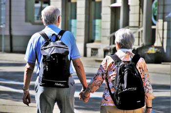 Elderly couple wearing packpacks