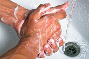 Soapy hands and running faucet