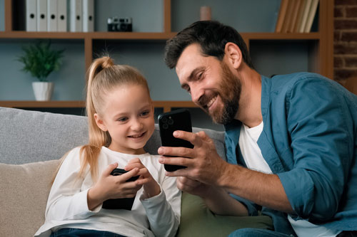 Dad and daughter looking at phones