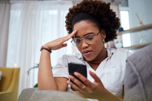 Woman stressed and holding cell phone