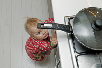 Toddler reaching for pan on stovetop