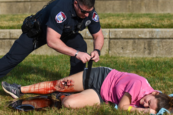 Police officer applying tourniquet