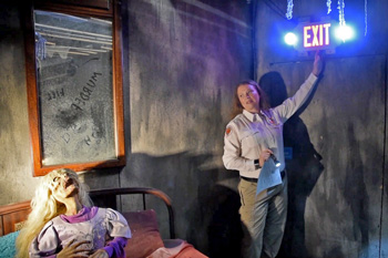 Inspector points to Exit sign in haunted house