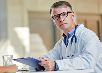 Man in suit with white doctor coat and clipboard