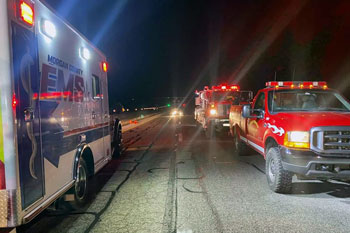 Fire and EMS vehicles, helicopter on road at night