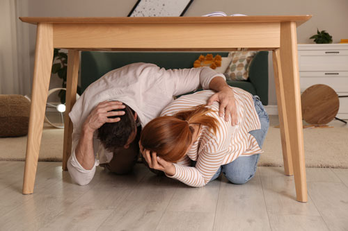 Adults under table during earthquake