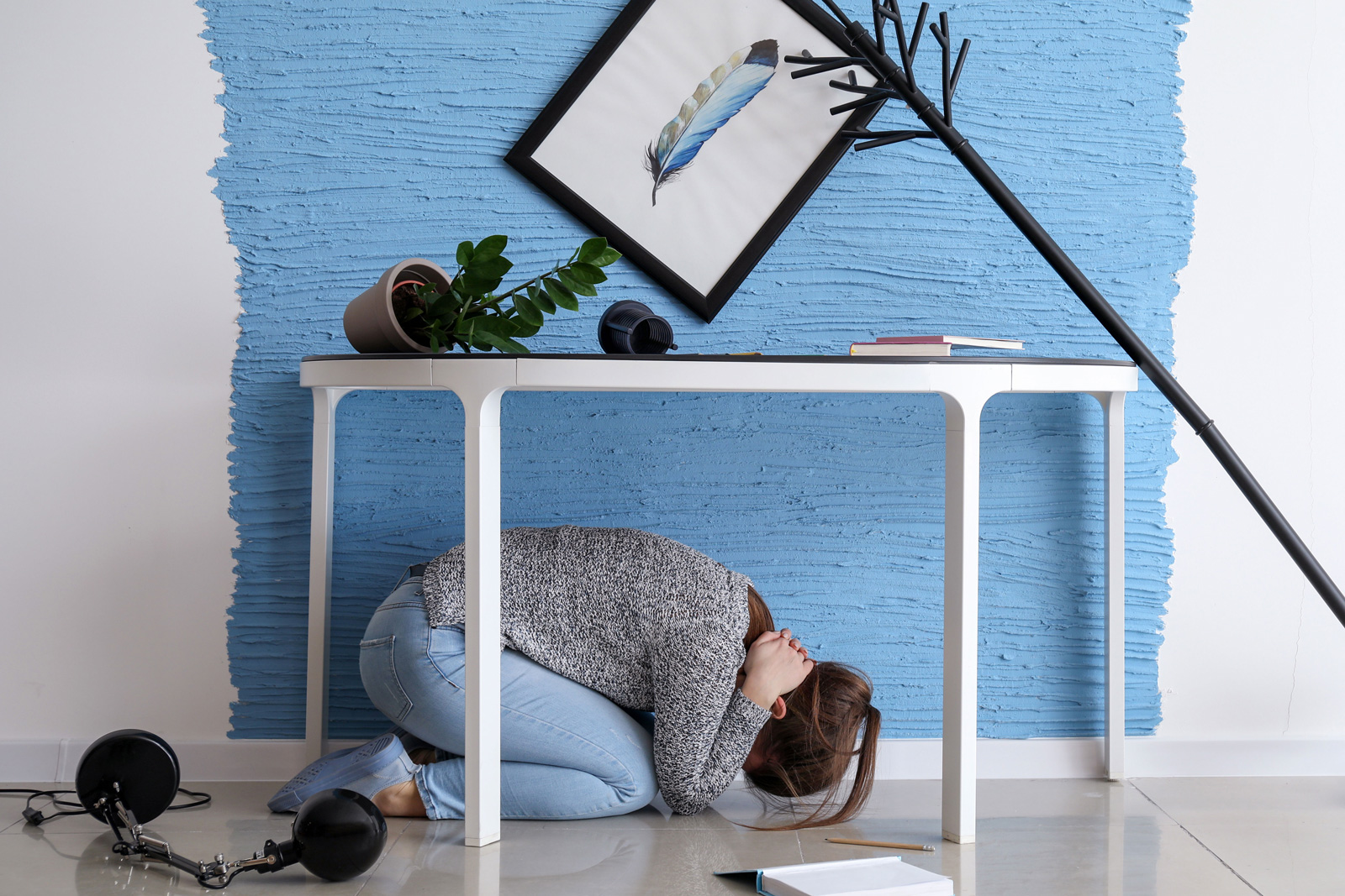 Woman crouching under table