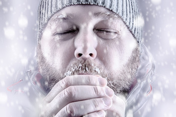 Man blowing on frigid hands