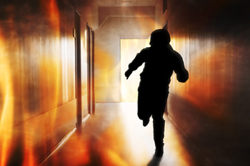 Person running down hallway with flames as background