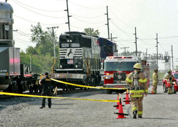 Firefighters and other personnel working near caution tape around train
