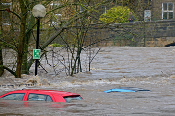 Flooded riverbank with cars submerged