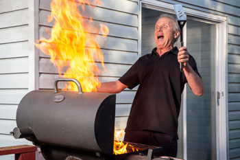 Grill shooting flames and man acting shocked