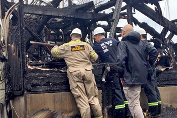 Fire investigators looking through debris at fire scene