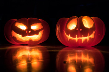 Two carved pumkins with spooky faces
