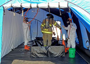 Firefighter hazmat training in tent with masks