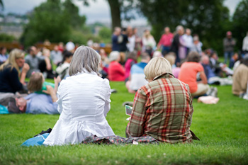 People sitting on blankets in grassy area