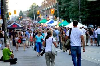 Couple with bags walking through busy street fair