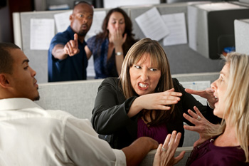 Angry woman reaching toward scared woman in office setting