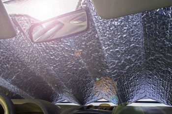 Car dashboard with reflective sun shield in windshield area