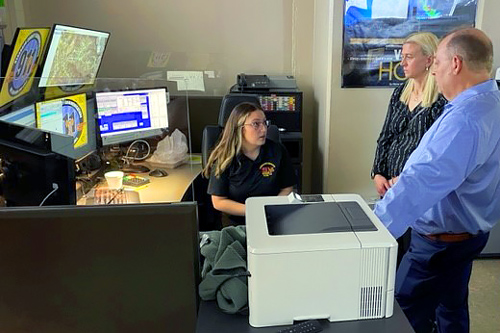 Dearborn County telecommunicator speaks with people at work station