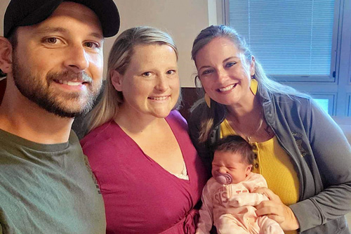Spencer County telecommunicator poses with newborn and parents