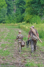 Dave Bare and his son Jacob, both of Somerset, carry gear to a Mississinewa Lake mourning dove hunting field. 