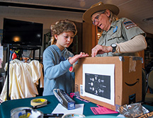 Spring Mill State Park seasonal interpretive naturalist Jill Lutes helps 8-year-old Natalie Henley build an eclipse viewer inside the park’s Lakeview Activity Center.