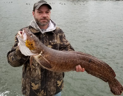 Anthony Burke of Cedar Lake holds the state-record burbot he caught, January 6, 2024 on Lake Michigan.