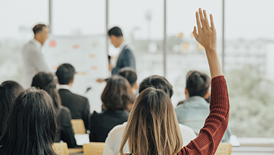 woman raising her hand in a classroom