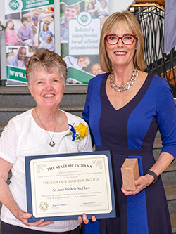 Picture of Sister Jane Michele McClure receiving the award from the Lieutenant Governor