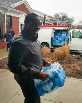 Image of employee carrying water to van