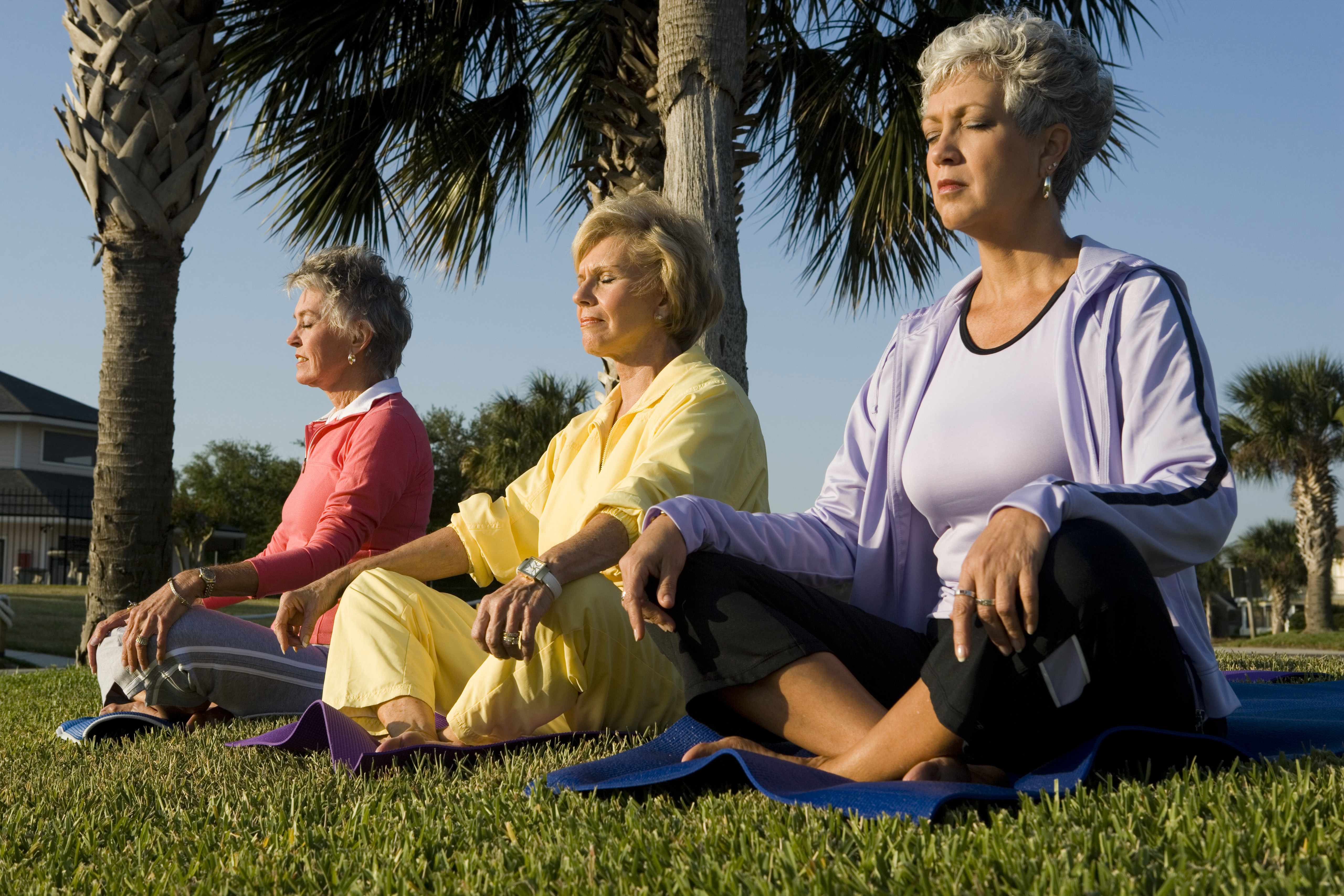 older women doing yoga outside